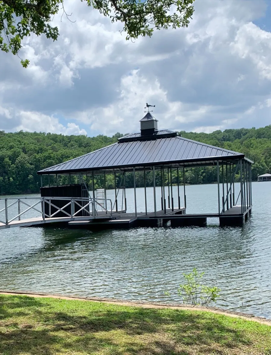 Covered steel boat dock with cupola and weathervane on the Smith Lake shoreline