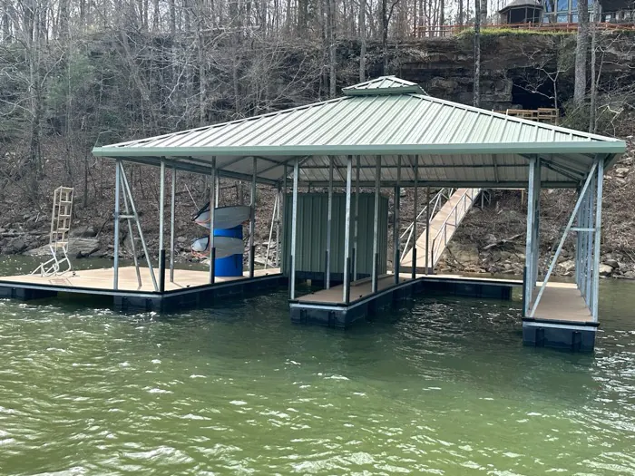 Covered boat dock with sage metal hip roof and kayak storage